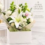 White floral arrangement in a gift box with lilies and orchids