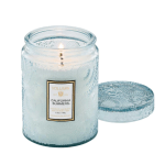 Lit candle in a blue glass jar with a matching lid