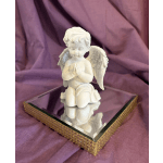 White angel figurine on a mirrored square base with gold trim