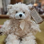 Fluffy teddy bear with a ribbon and hanging gift tag