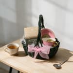 Tea gift basket with a cup, teacup, and pink ribbon