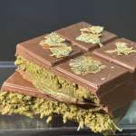 Stacked chocolate bars with green filling and gold leaf on top