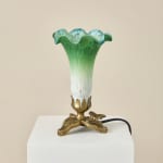 Green and blue glass vase lamp on a white pedestal