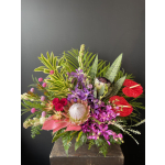 Tropical bouquet with purple orchids, red anthuriums, and a protea in a vase
