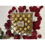 Box of Ferrero Rocher chocolates surrounded by red rose petals