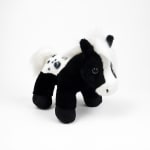 Black-and-white plush cow toy on a white background