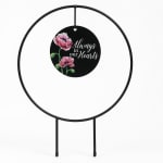 Black memorial sign with pink flowers and the words "Always in our hearts"