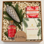 Holiday gift box with a candle, soap, matches, and a silver pinecone ornament