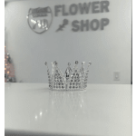 Small silver rhinestone crown on a white surface