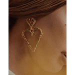 Heart-shaped dangling earrings with green stones on a person’s ear