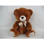 Brown teddy bear with a bow sitting against a plain background