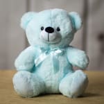 Light blue teddy bear with a satin ribbon