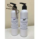 Two bottles of goat milk lotion with pump tops and twine bows