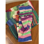 Stack of colorful knitted scarves on a wooden table