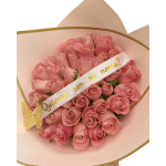 Bouquet of pink roses wrapped in pale pink paper with a ribbon
