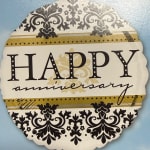 Decorative "Happy anniversary" sign with black floral patterns on a blue background