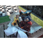 Gift basket with snacks, fruit, and a white ribbon