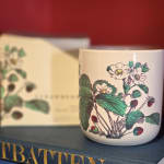 Floral-printed ceramic mug on a book with a matching box behind it