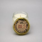 Glass jar candle with a gold lid labeled Spiced Orange