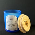 Blue candle jar with a wooden lid and label