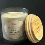 Scented candle in a glass jar with a wooden lid beside it