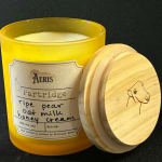 Yellow scented candle in a glass jar with a wooden lid