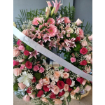 Large pink and red floral wreath with roses, lilies, and gerbera daisies