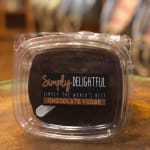 Chocolate fudge in a clear plastic container with a label