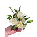White rose boutonniere with small blossoms and glossy leaves