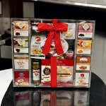 Gift basket of assorted snacks and crackers tied with a red ribbon
