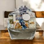 Gift basket with assorted crackers, olives, and cheese spread in clear wrap