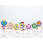Assorted celebration cake tins with colorful labels on a marble surface