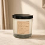 Glass jar candle with a black lid and fall-themed label
