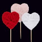 Three heart-shaped lollipops in red, pink, and white