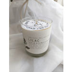 A lilac-scented candle in a clear glass jar with a white label