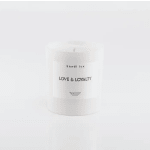 White scented candle in a glass jar labeled Love & Loyalty