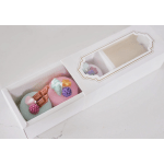 Two decorated round soaps in a white gift box with a clear window