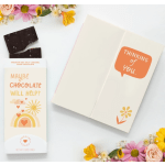 Chocolate bar and a thinking-of-you card beside pastel flowers