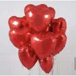 Cluster of red heart-shaped balloons against a light background