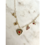 Gold charm necklace with red and pink heart pendants on a marble surface