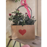 Red rose bouquet in a kraft paper gift bag with a pink heart ribbon