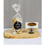 Bag of gold and silver wrapped chocolates with a business card holder on a wooden board