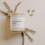 Lavender and sage scented candle in a glass jar with dried botanicals
