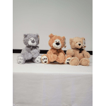 Three plush teddy bears sitting side by side on a table