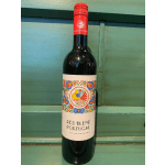 Bottle of red wine with a colorful label on a green wooden surface