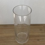 Tall clear glass cylinder vase on a wooden surface