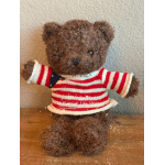 Brown teddy bear wearing a red and white striped sweater