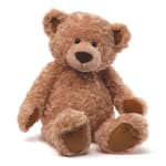Soft tan teddy bear plush toy sitting upright with outstretched legs.