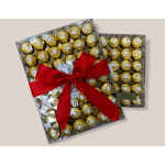 Two boxes of gold-wrapped chocolates tied with a red ribbon