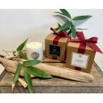 Gift set with two boxed candles and a glass candle jar on driftwood